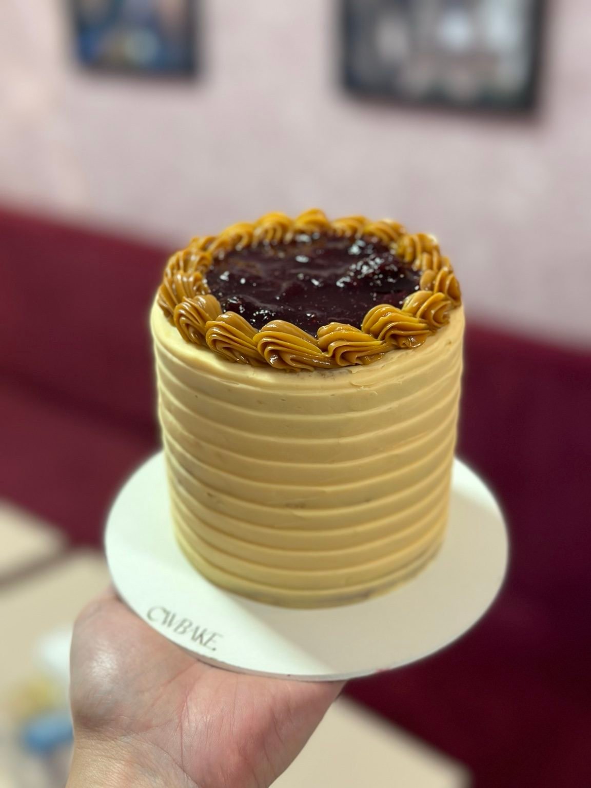 Bolo com buttercream em faixas e geleia de frutas vermelhas no topo