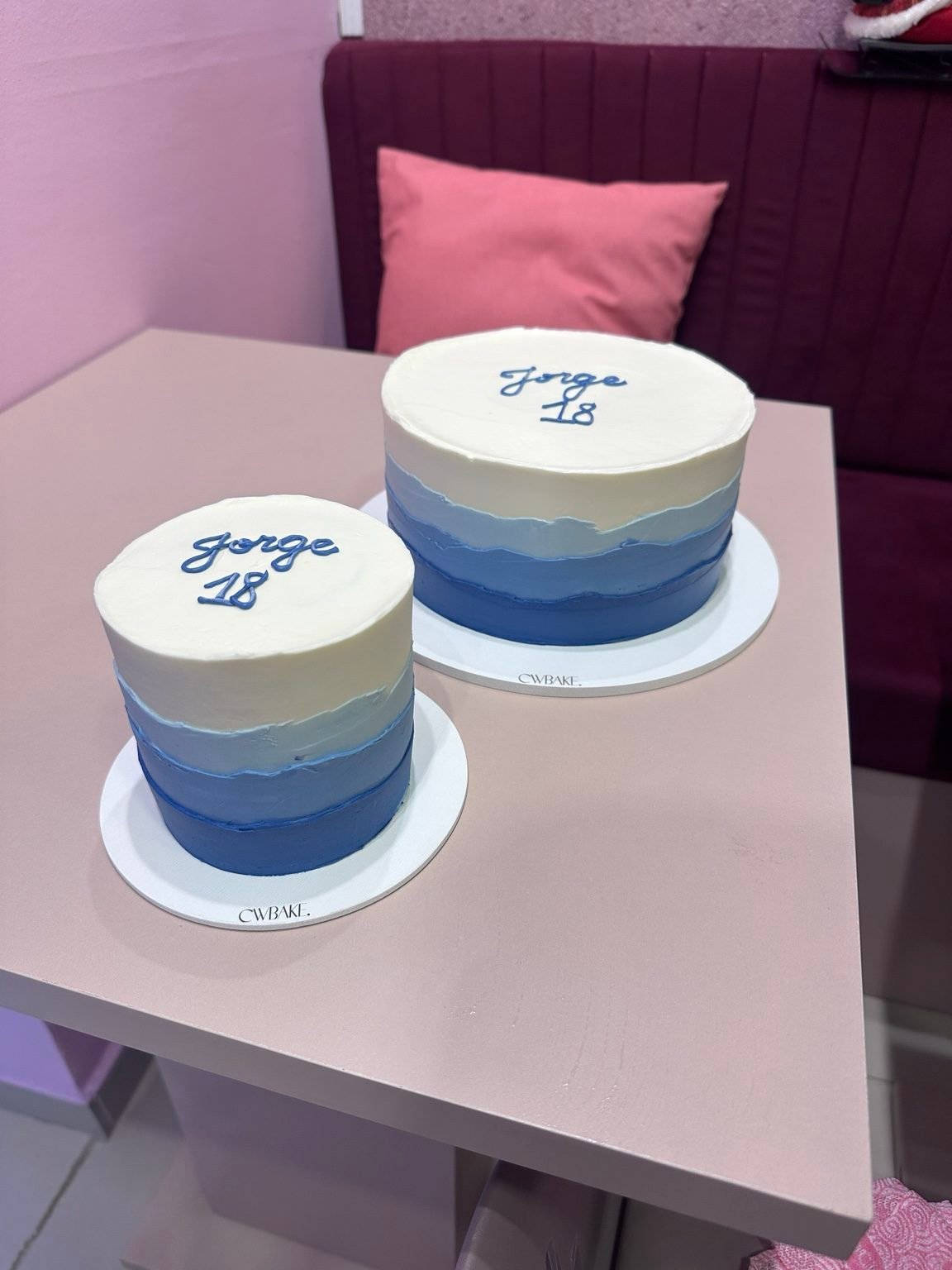 Dois bolos em degradê de azul com nome escrito no topo