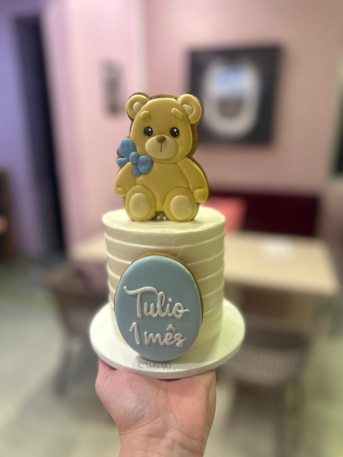 Bolo com biscoito decorado de ursinho e placa com nome