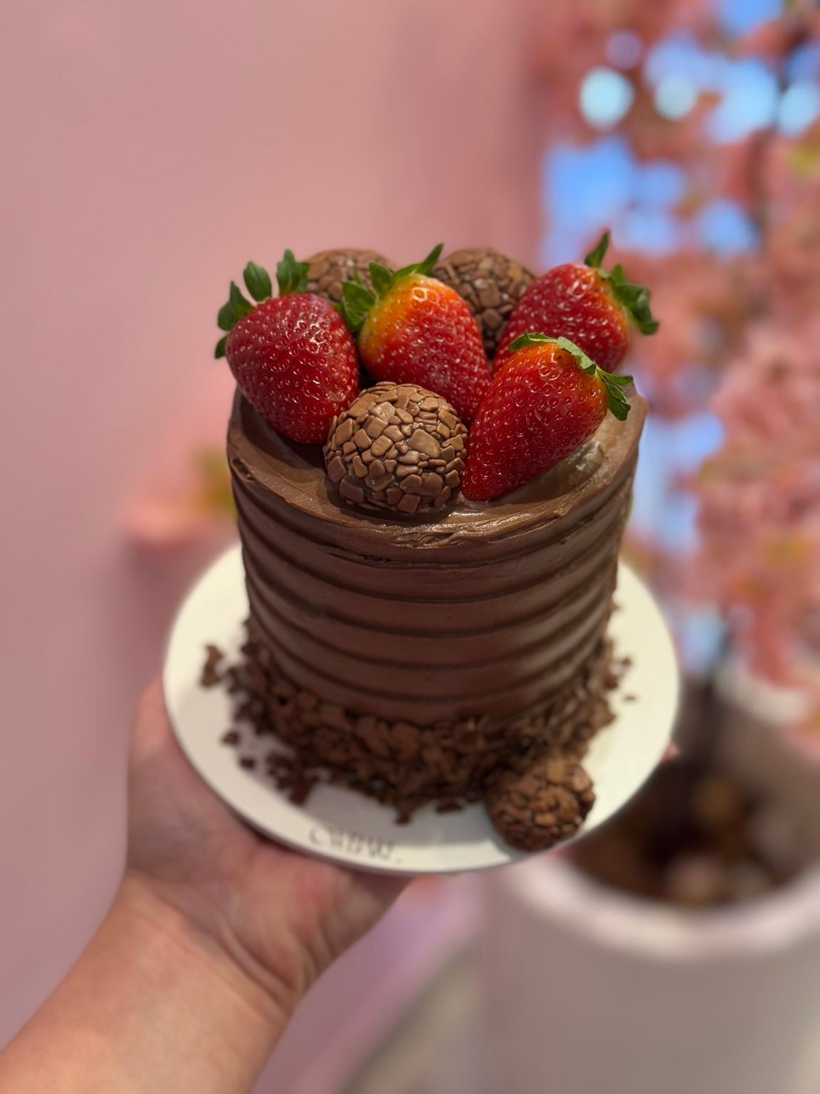 Bolo de chocolate com textura, morangos e brigadeiro no topo