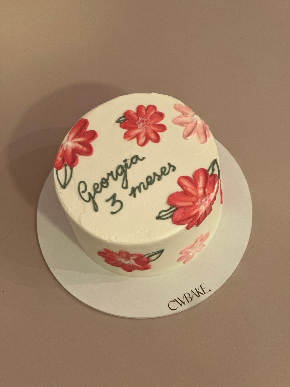 Bolo creme com flores vermelhas pintadas à mão e nome escrito