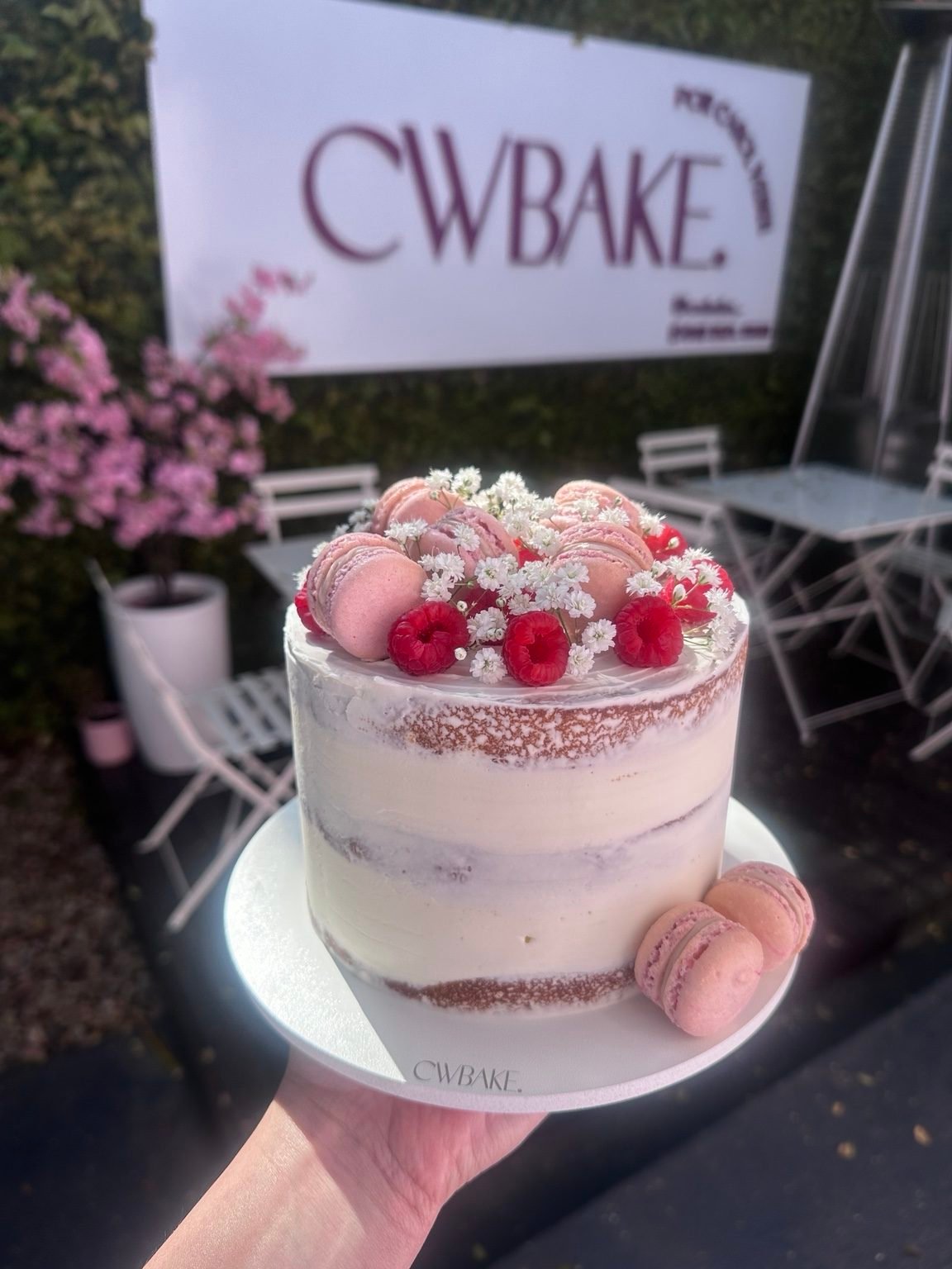 Bolo naked com frutas vermelhas, flores e macarons cor-de-rosa