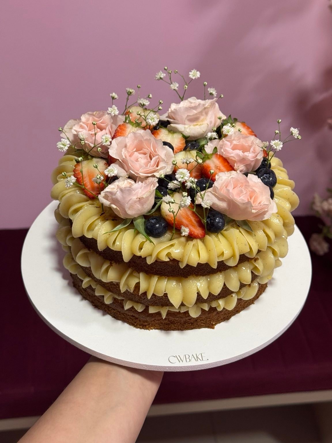 Bolo naked com rosas naturais e frutas vermelhas no topo