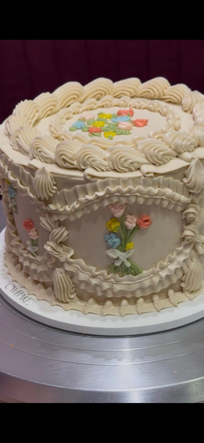 Bolo vintage creme com babados, buquês de flores pintados e borda em conchas