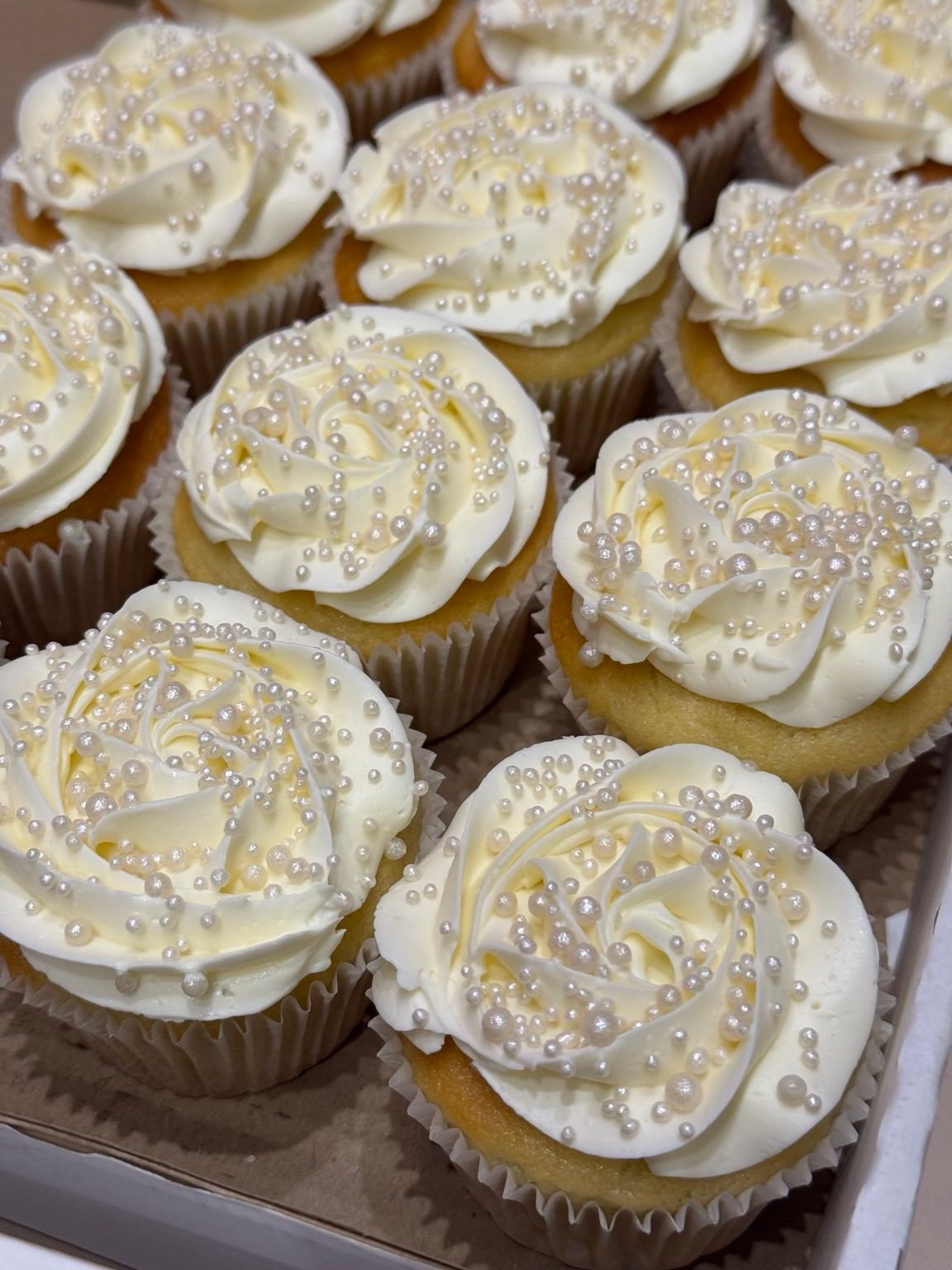 Cupcakes com cobertura branca e pérolas de açúcar